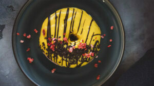 Krofna punjena eurokremom na stolu sa tamnom podlogom