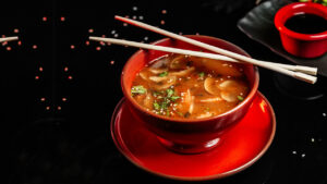 Gulaš od pečuraka serviran u tanjiru sa crnom pozadinom